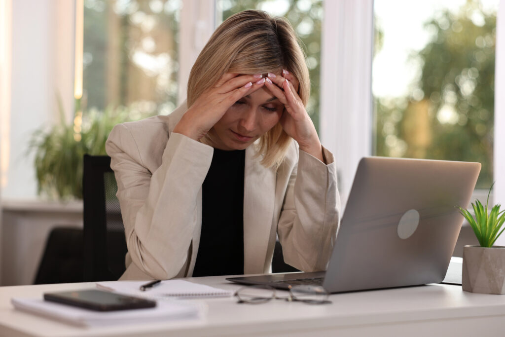 professional woman at desk with hands over forehead stressing over email marketing best practices